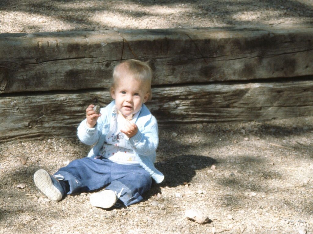 One-year-old sitting in the dirt and rocks of a Colorado campsite, 1988.
